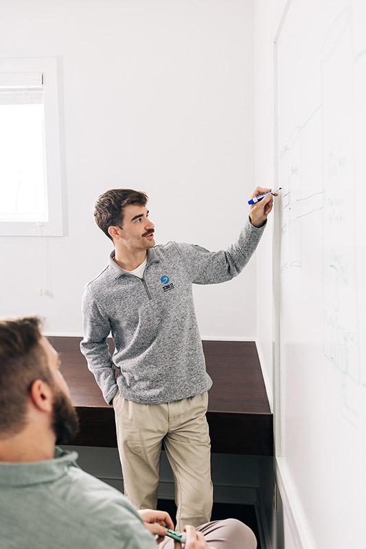man writing on whiteboard